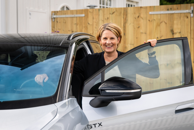 Sara som kliver in i sin elbil, Volkswagen ID. 3.
