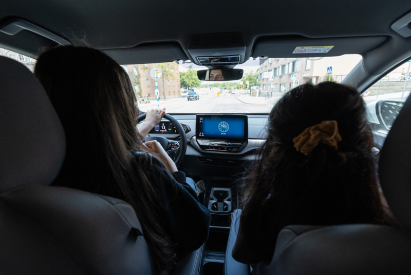 Två personer sitter i förarsätet och passagerarsätet i en Volkswagen