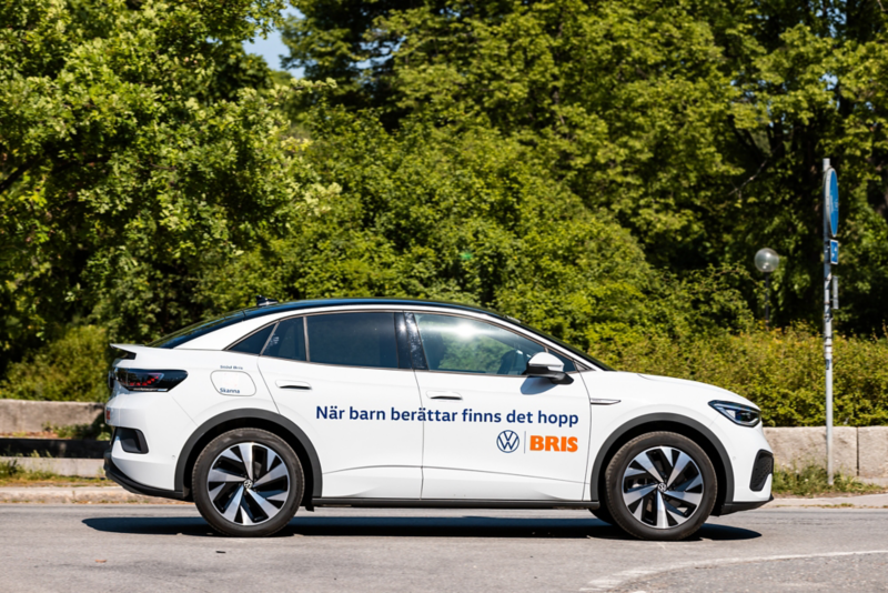 Vit Volkswagen ID.5 står parkerad med träd i bakgrunden