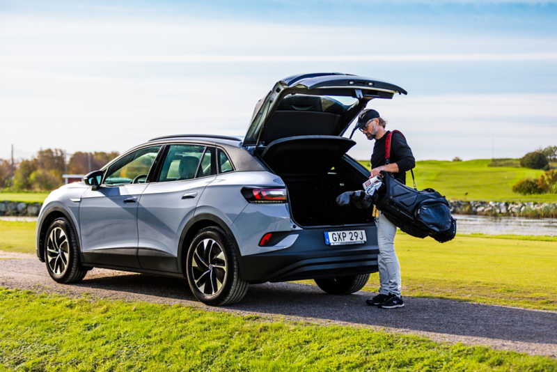 Filip Lindkvist lastar golfbag ut bagageutrymmet på en Volkswagen ID.4, parkerad vid en golfbana