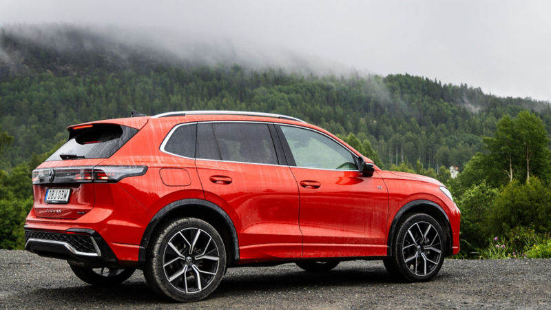 En röd Volkswagen SUV står parkerad nedanför ett dimmigt berg