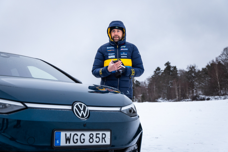 Rikard Grip står vid Volkswagen ID.7 i ett vinterlandskap.