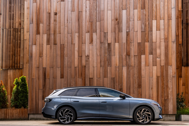 En ID.7 Tourer står parkerad framför en träfasad. 