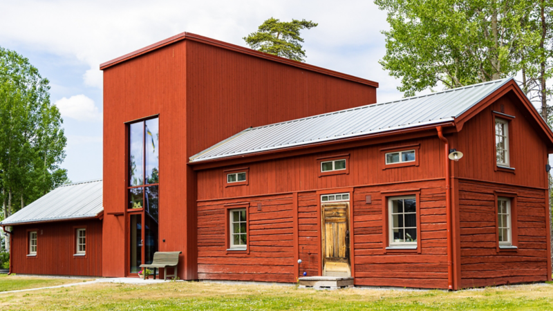 Ett rött trähus i sommarmiljö