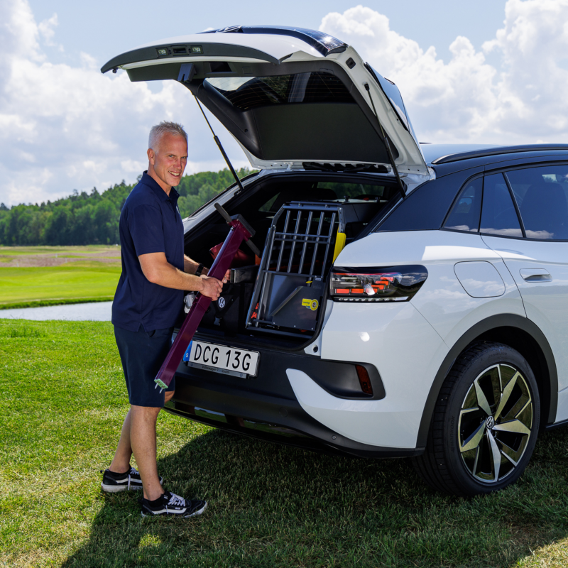 Bakdelen på en vit Volkswagen ID.4 parkerad på en golfbana, Henrik lastar in bagage