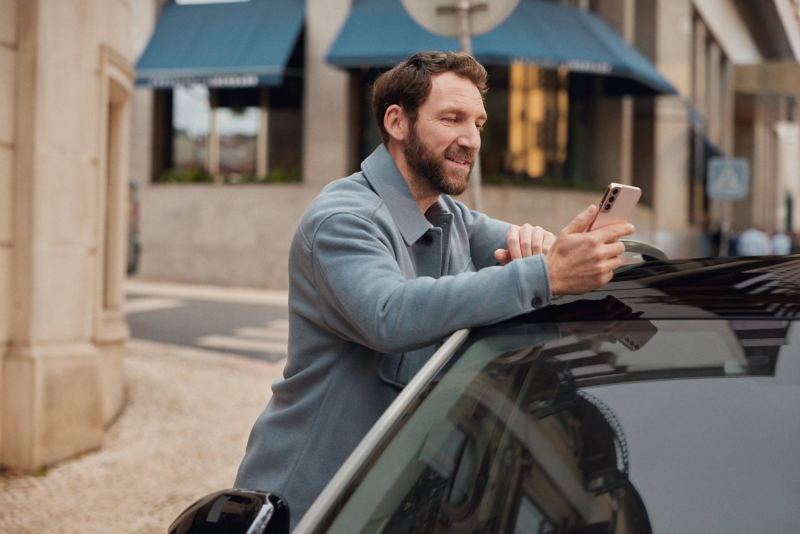 Man leaning against car on his phone