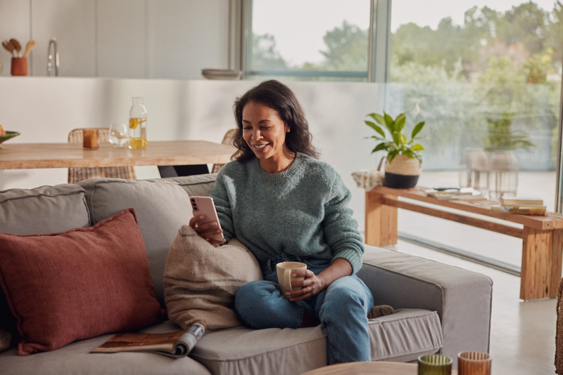Woman sat on the couch looking at phone
