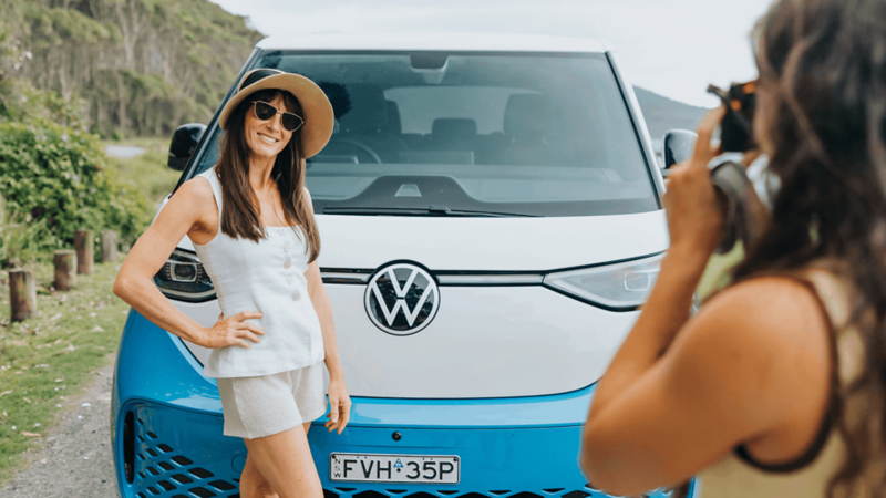 Kids sitting in ID Buzz silver with her sister standing outside