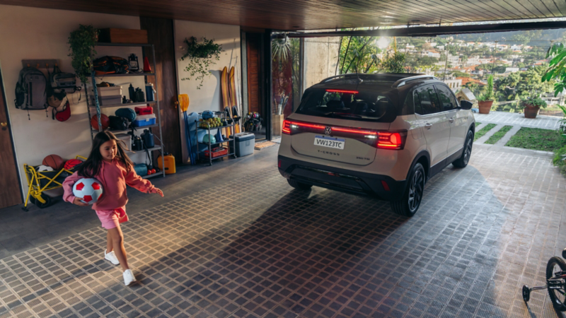 Volkswagen Ecuador: SUV moderno en garaje con niña jugando al fútbol, destacando seguridad y tecnología de Impoventura C.A.