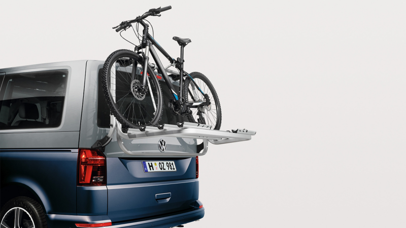 Tailgate bicycle carrier accessory with bike attached to the back of a California Van