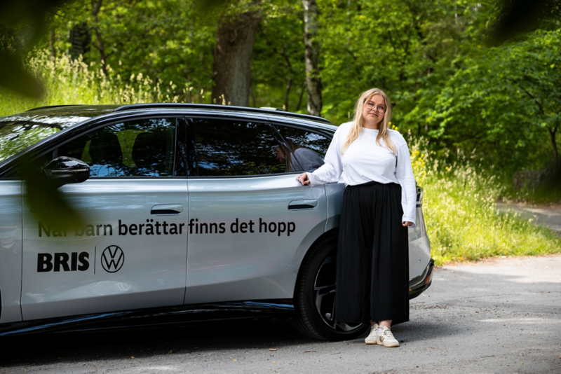 Bris kurator Jennifer Pettersson står vid en Volkswagenbil med Bris och Volkswagenlogga