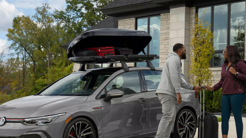 Volkswagen GTI in a driveway with owners packing cargo box.