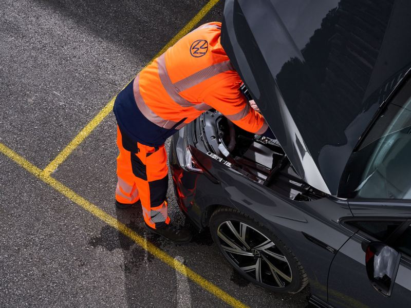 Emergency responder looking at vehicle.