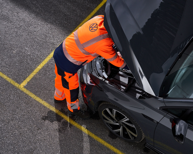 Emergency responder looking at vehicle.