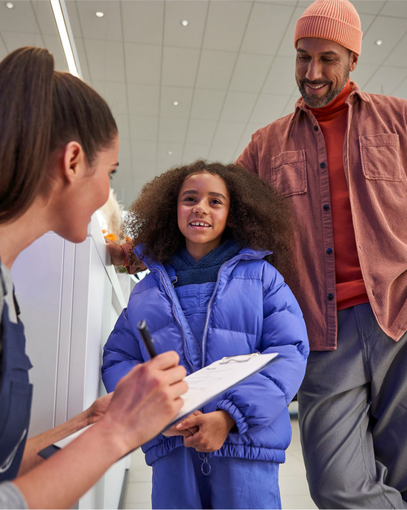 Man and young girl in Volkswagen dealership speaking with VW employee.