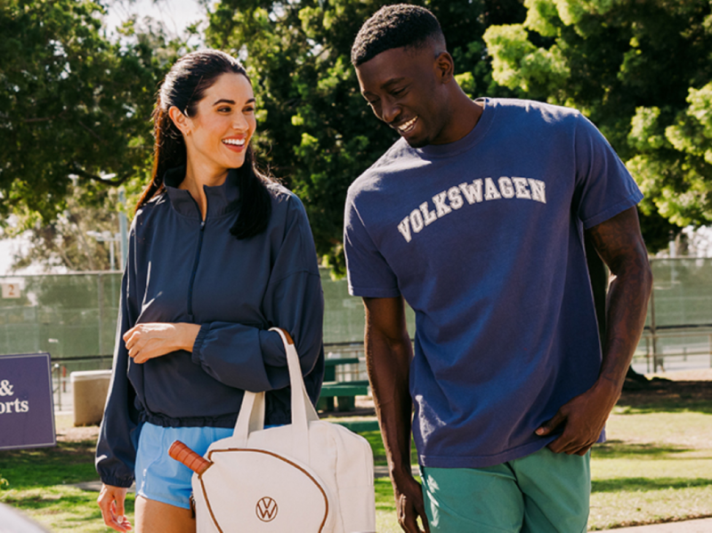 A couple walking toward a Volkswagen vehicle wearing athletic clothing.