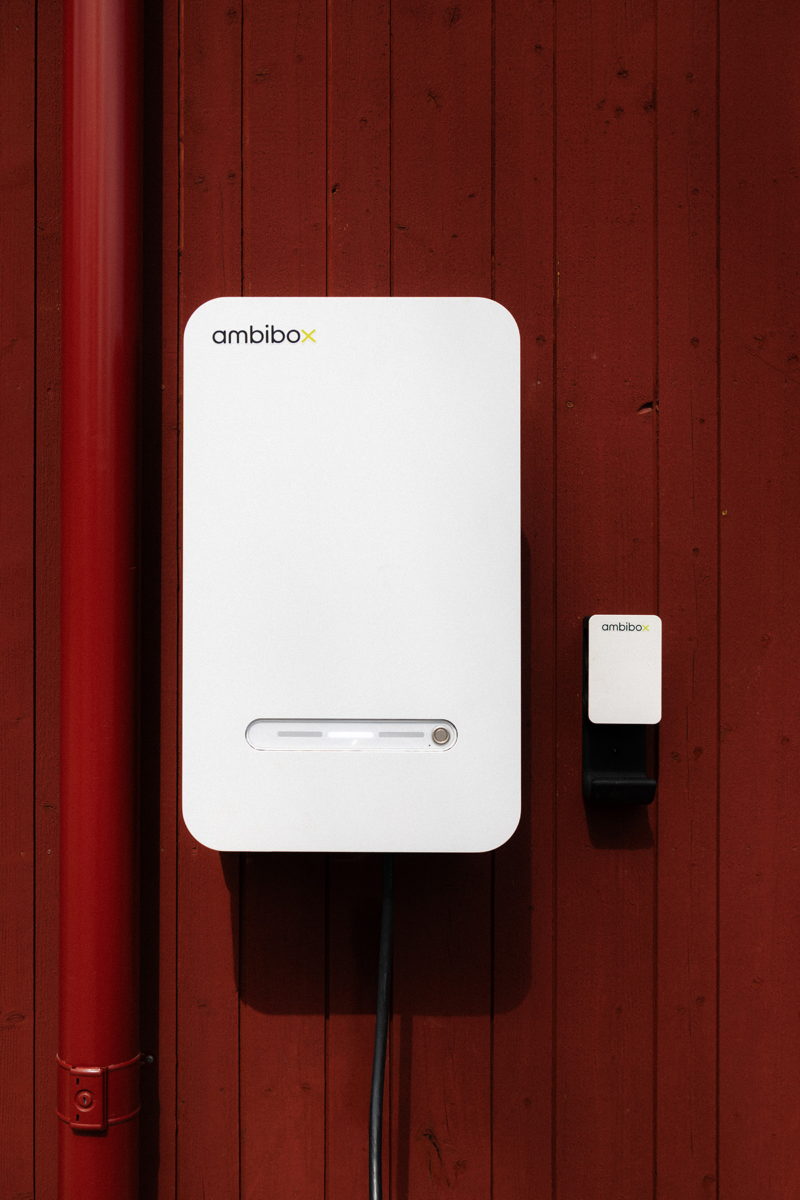 Laddbox från Ambibo hänger på en rödmålad vägg