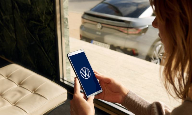 Woman using myVW app to control VW vehicle.