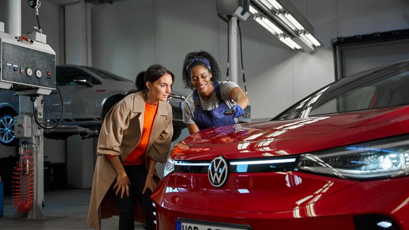 VW-servicemedewerker en klant kijken naar het lakwerk van een VW ID.5 GTX