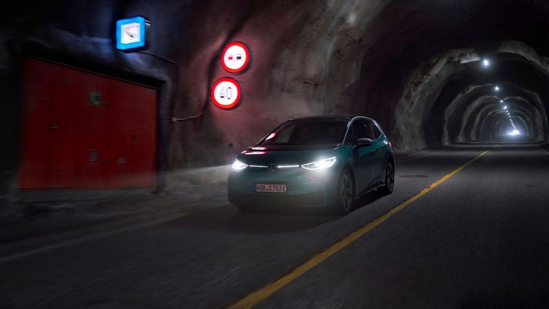 A VW ID.3 with glowing headlights in a tunnel