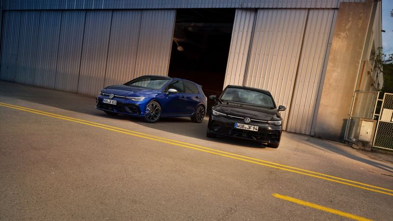 Zwei Autos von VWR vor Fabrikhalle – VW Golf R und VW Golf R Black Edition