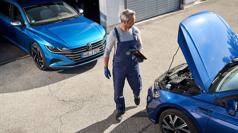 A VW service employee at an opened bonnet – VW Vehicle Check