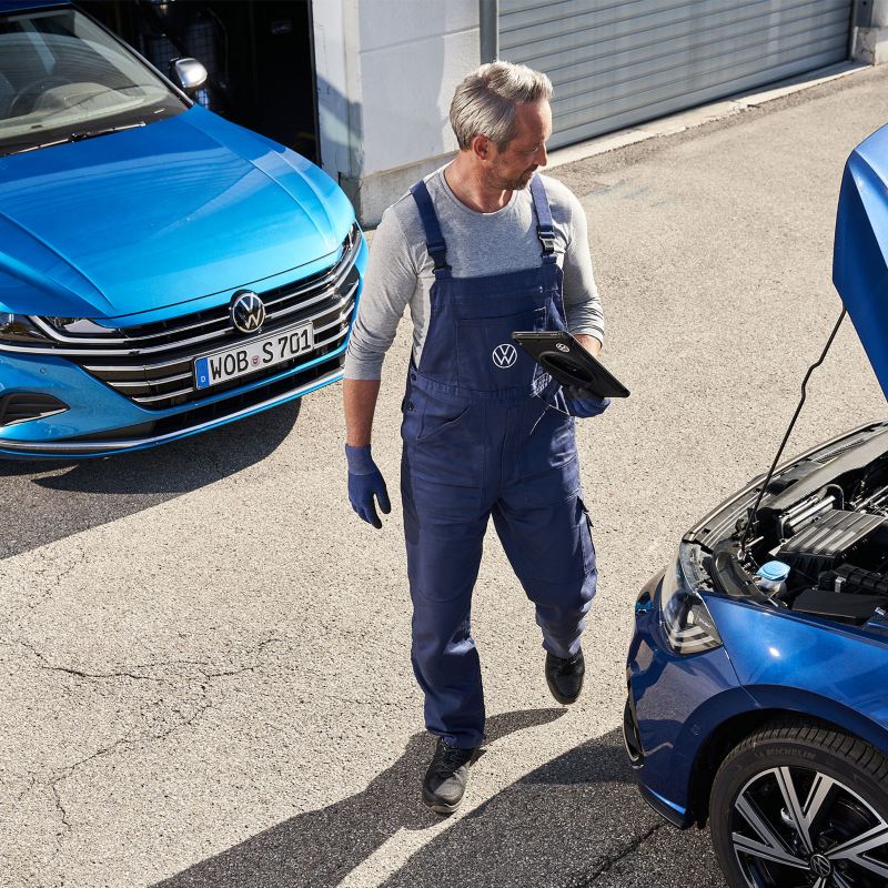 A VW service employee at an opened bonnet – VW Vehicle Check