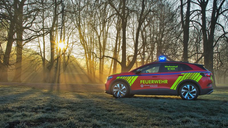 Ein VW Notfallfahrzeug steht vor einem Wald, Sonne scheint durch die Bäume