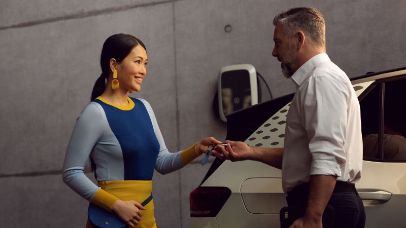 A VW employee handing over their ID. to a customer 