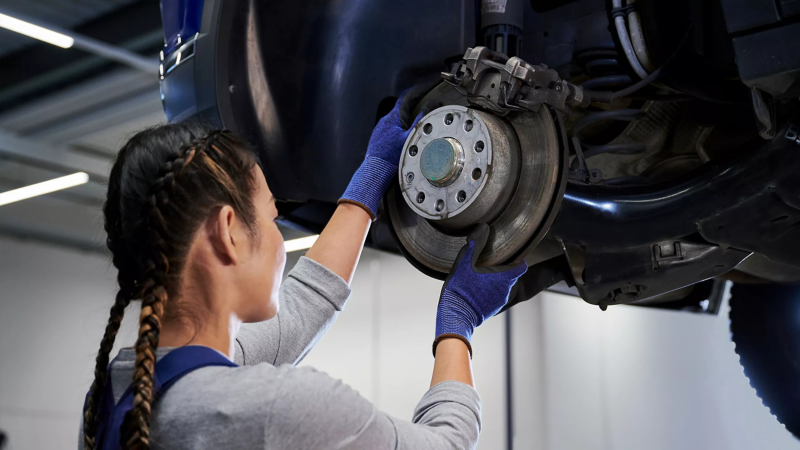 Volkswagen monteur bekijkt een remschijf in de werkplaats