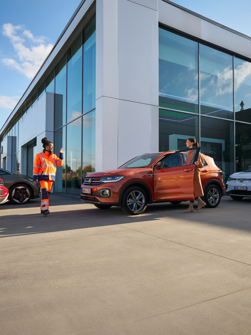 Υπάλληλος service της VW υποδέχεται τον πελάτη σε ένα αυτοκίνητο VW – Εγγύηση Κινητικότητας