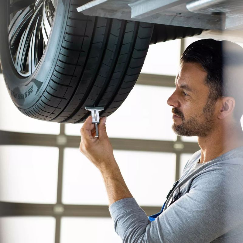 Un technicien Volkswagen Véhicules Utilitaires vérifie le niveau d'usure d'un pneumatique