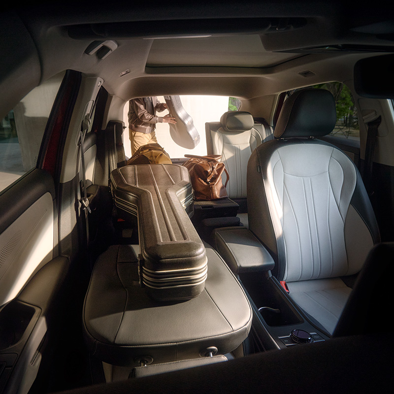 Ruim interieur van een Volkswagen: de neergeklapte achterbank biedt plaats aan een gitaarkoffer en reistassen.