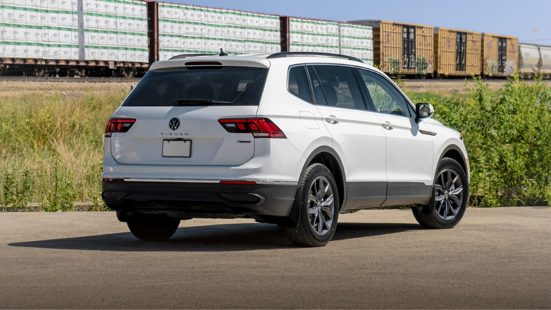 A white Volkswagen Tiguan parked near the railway