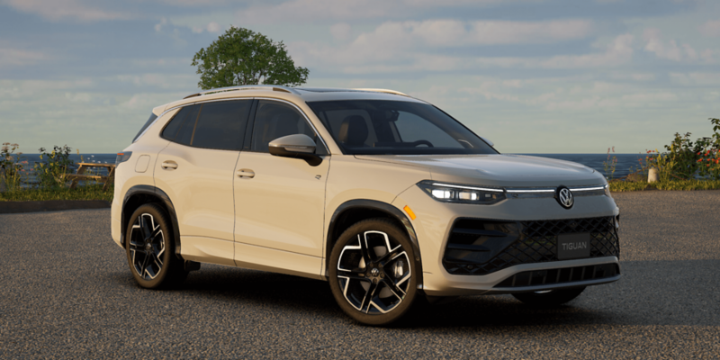 Un élégant VUS Volkswagen Tiguan blanc est présenté sur un terrain de soccer vert vif, entouré de gradins de stade et d'équipements d'entraînement. Le véhicule est positionné en angle, mettant en valeur son design moderne et sa calandre audacieuse.