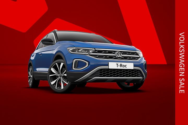 A blue T-Roc front view from low angle on a red background