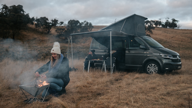 Couple camping with the California Van making a Bonfire 
