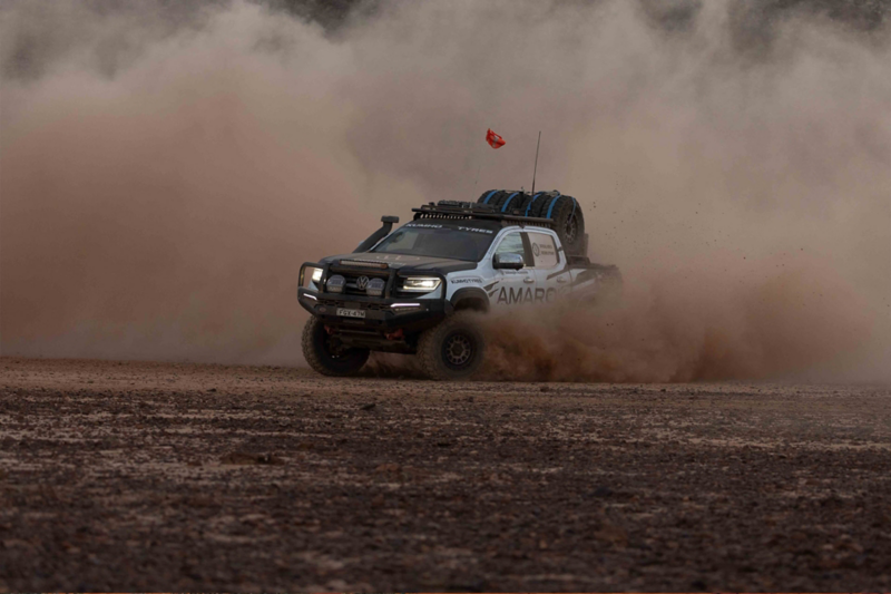 VW Amarok driving in desert with dust plume 