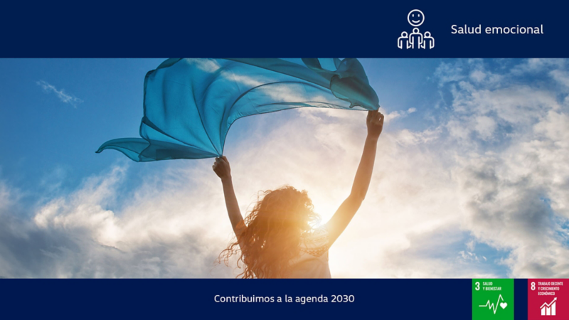 Mujer sujeta una tela transparente que mueve el viento en un paisaje con cielo azul y nubes. 