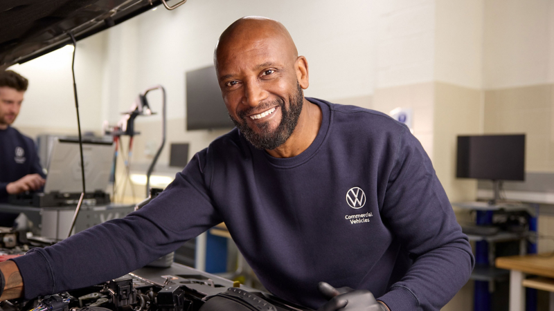 Photo showing a VW technician working on a vehicle. 