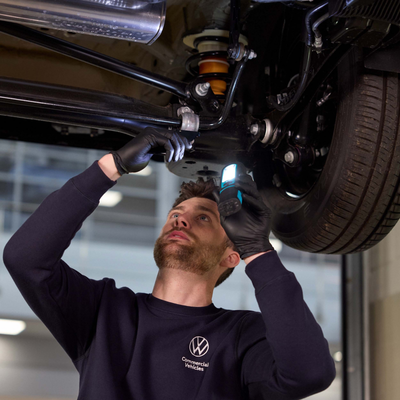VW technician working on a van battery