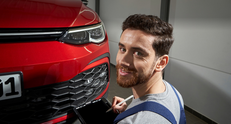 VW ID.5 GTX mit geöffneter Motorhaube – Familie mit VW Servicemitarbeitendem während des Batterieservices