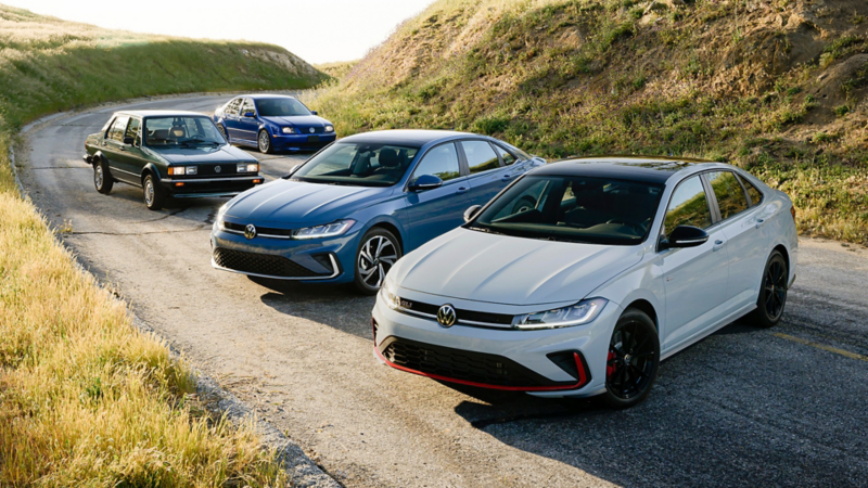 Lineup of four sedans parked on a winding road, showcasing different generations of the same model, highlighting evolution in design from classic to modern performance styling.