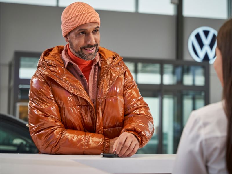 Customer at counter in VW dealership.