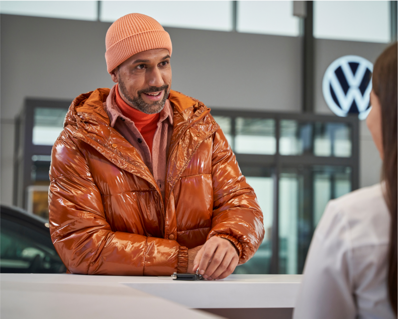 Customer at counter in VW dealership.