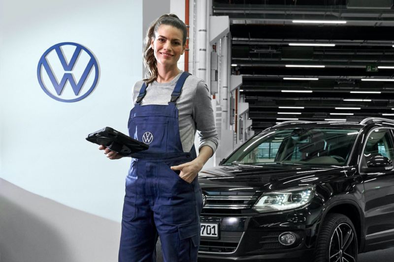 Agente de servicio de Volkswagen sonriendo en un taller