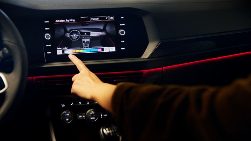A person is changing interior ambient lighting on the dashboard of the 2023 Volkswagen Jetta GLI 