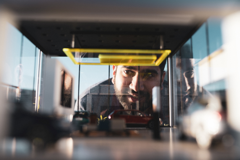 Man looking through worlds smallest dealership model