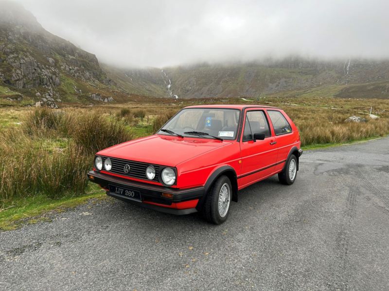 Volkswagen Red Golf with Mountains in Background 