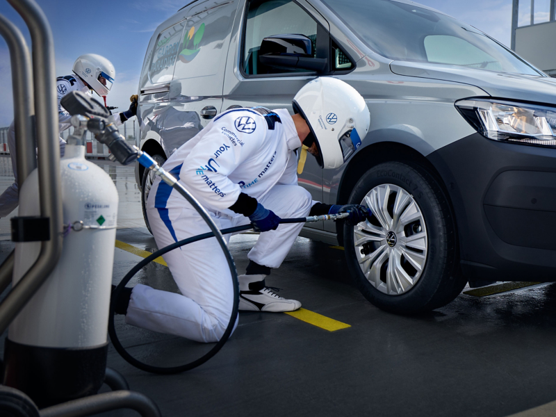 VW Connect Boxenstopp Team tauscht Reifen eines Caddy Cargo.